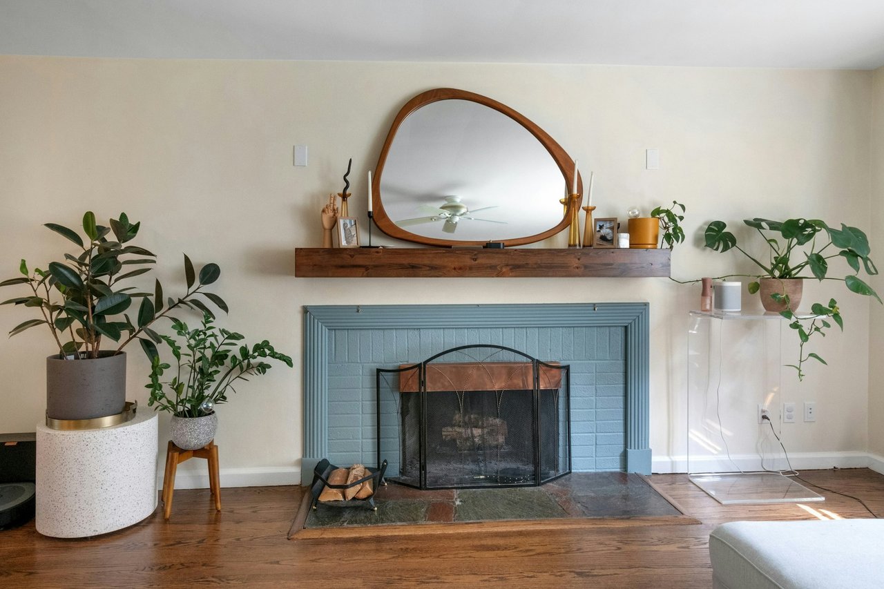 Detailed view of wood finished floors, a fireplace, and a ceiling fan