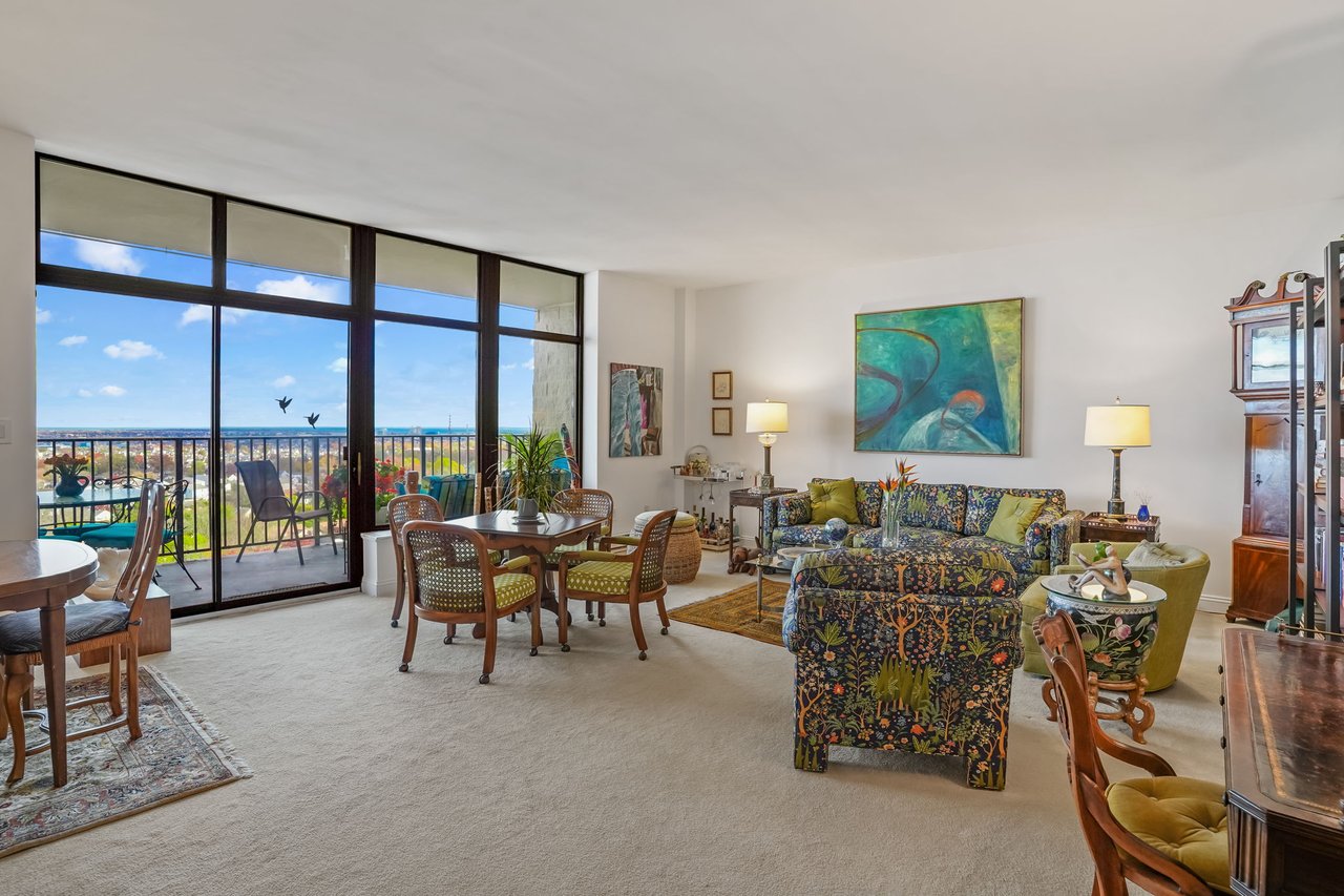 View into living room with soaring ceiling and wall to wall carpet.