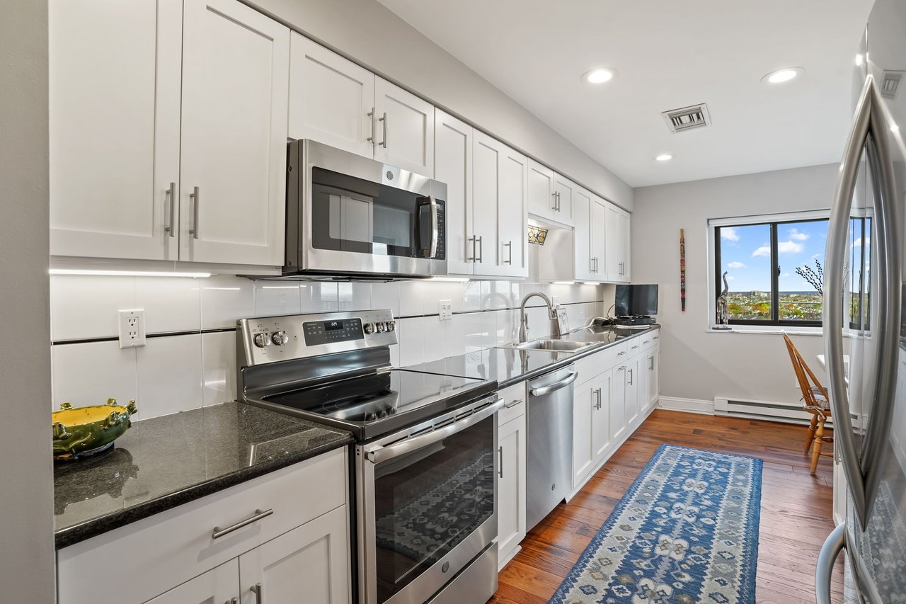Kitchen with hardwood floors and stainless steel appliances.