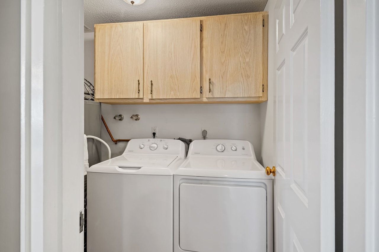 Laundry room with storage and full size washer and dryer located off kitchen.