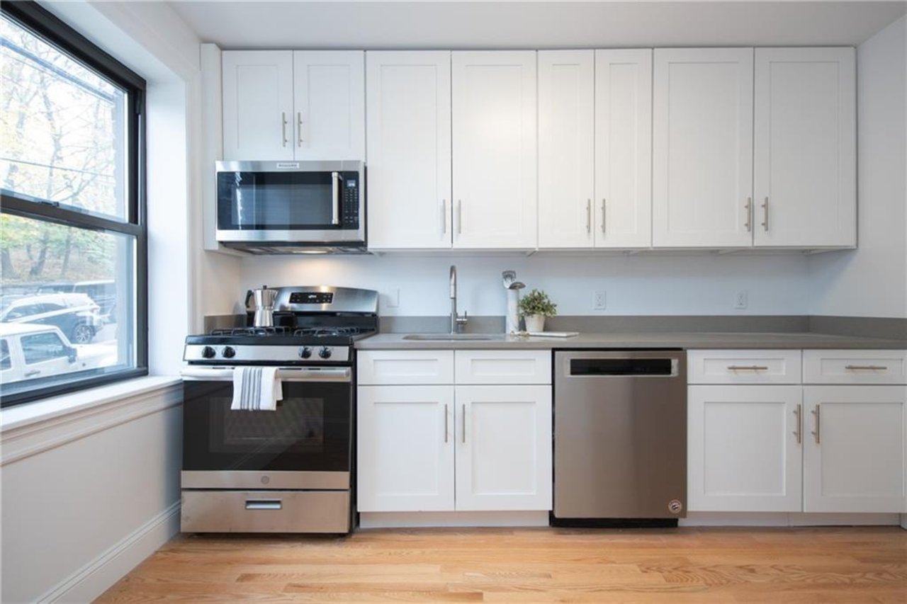 Kitchen featuring white cabinetry, sink, stainless steel appliances, and light wood-type flooring