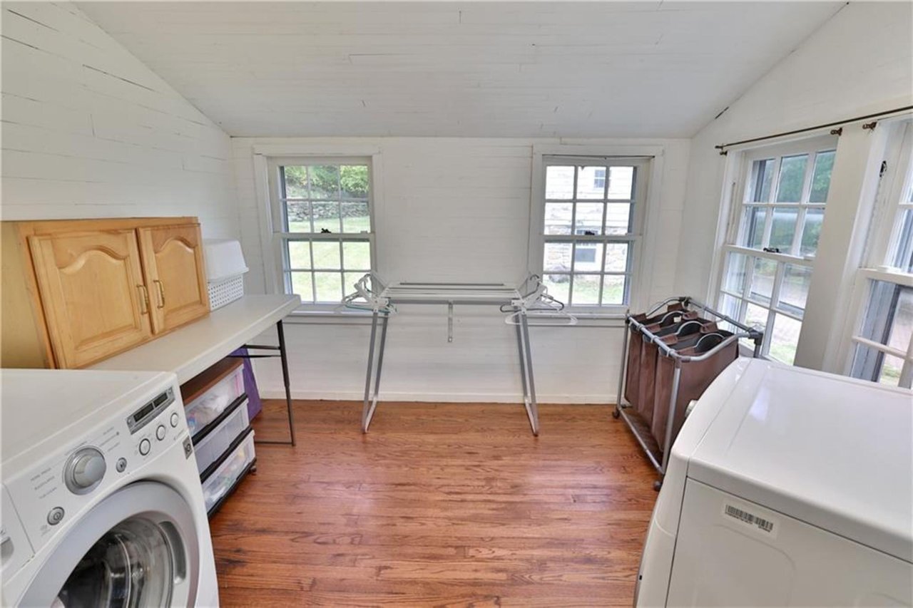 Washroom featuring lofted ceiling, light wood-type flooring, and washer and dryer
