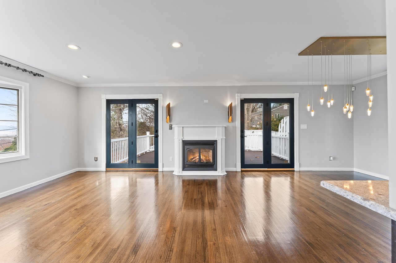 Unfurnished living room with french doors, ornamental molding, recessed lighting, a glass covered fireplace, and wood finished floors