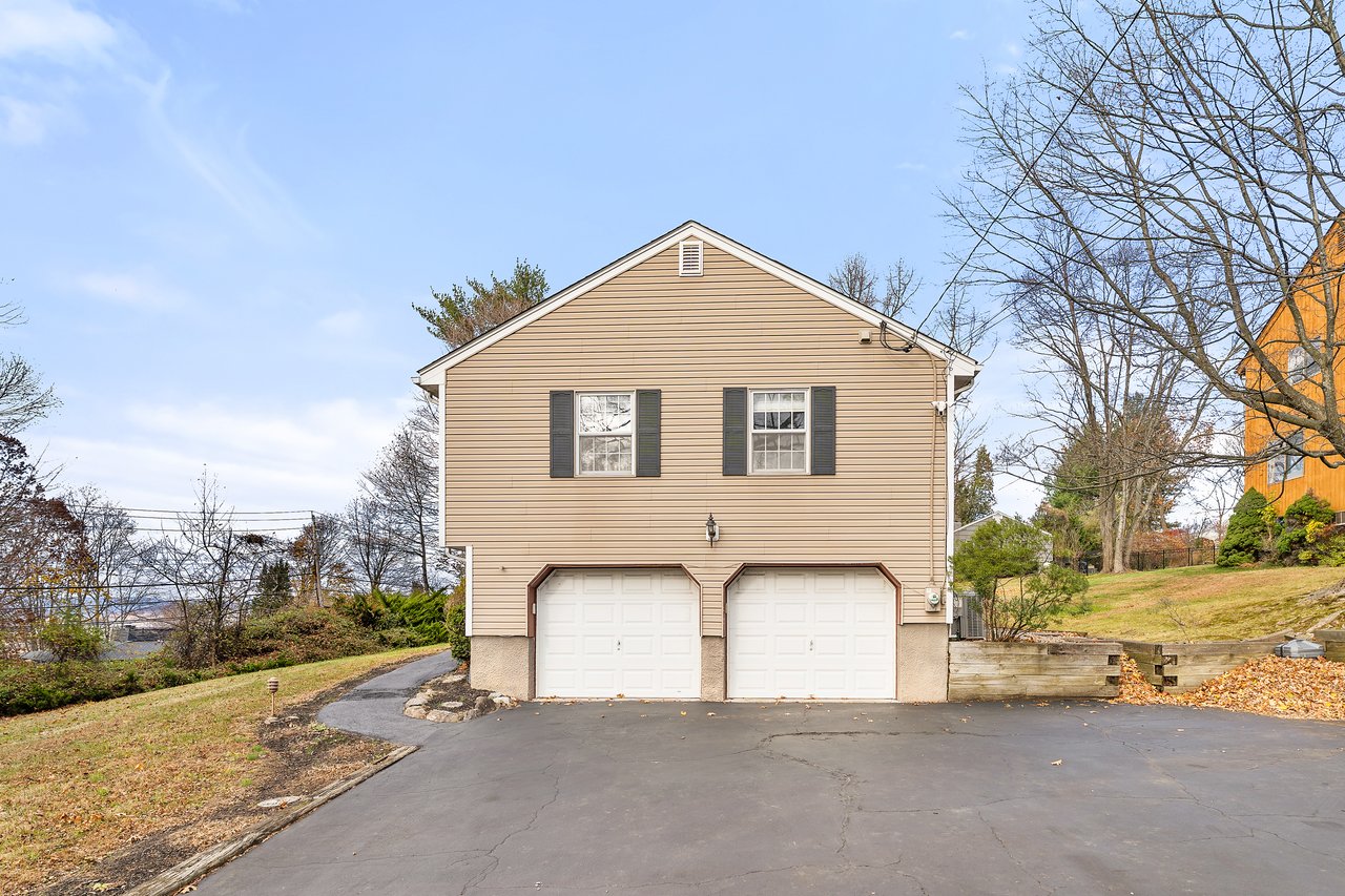 View of front of property with asphalt driveway, a garage, and a front yard