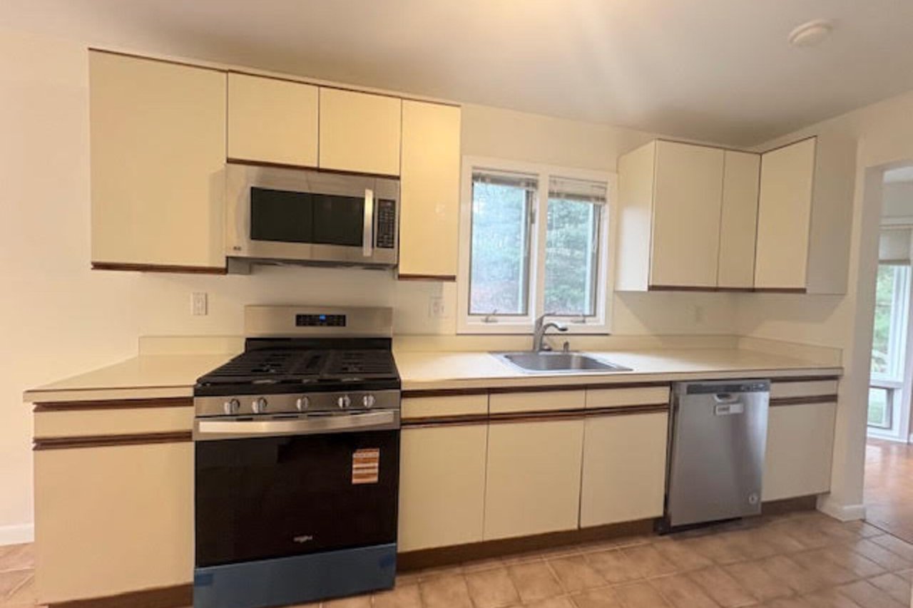 Kitchen with appliances with stainless steel finishes, light countertops