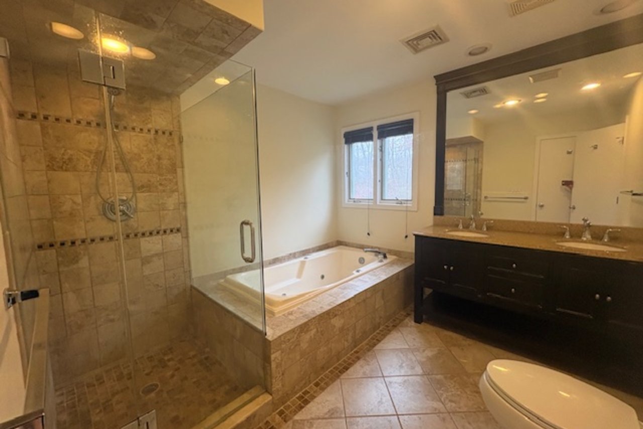 Full bath with a stall shower, double vanity, and a soaking tub