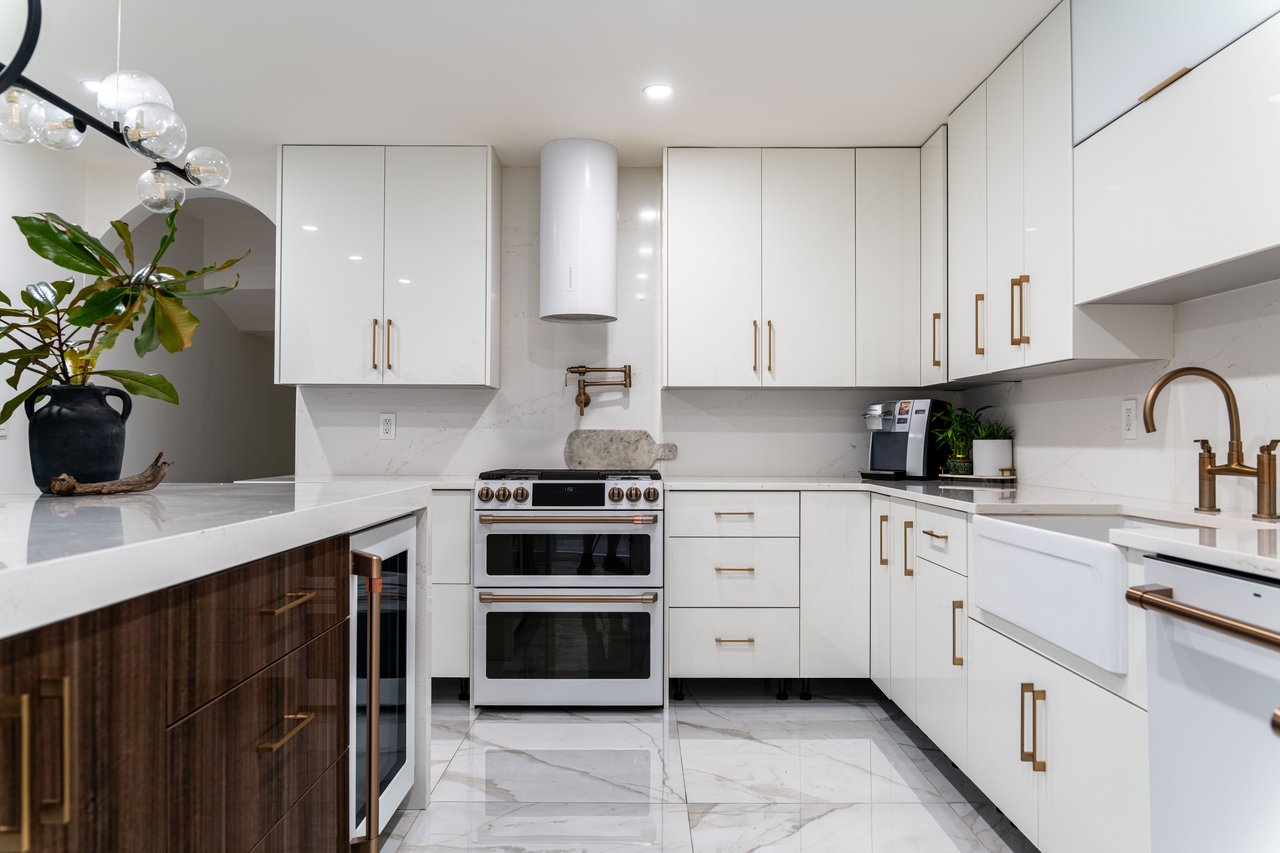 Kitchen with white cabinets, modern cabinets, white appliances, light stone countertops, and recessed lighting