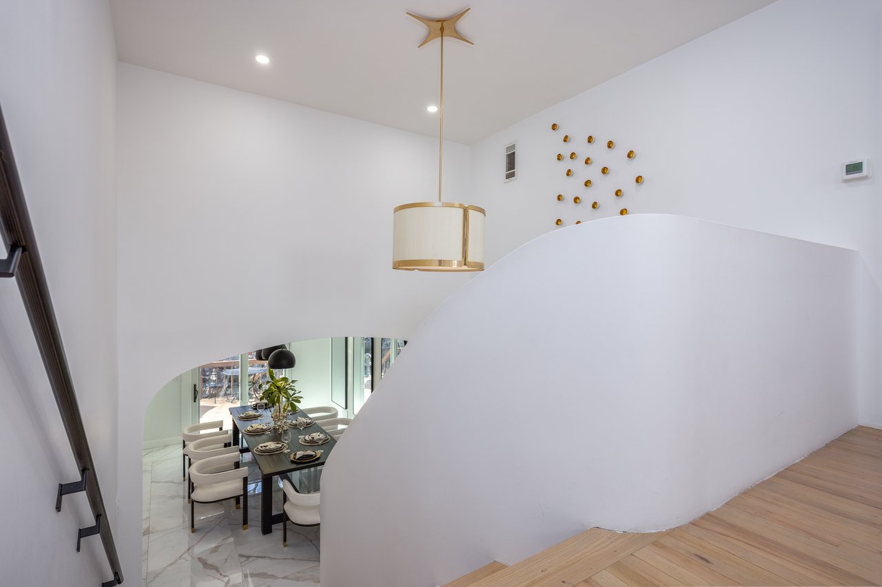 Staircase featuring marble finish flooring, recessed lighting, and arched walkways