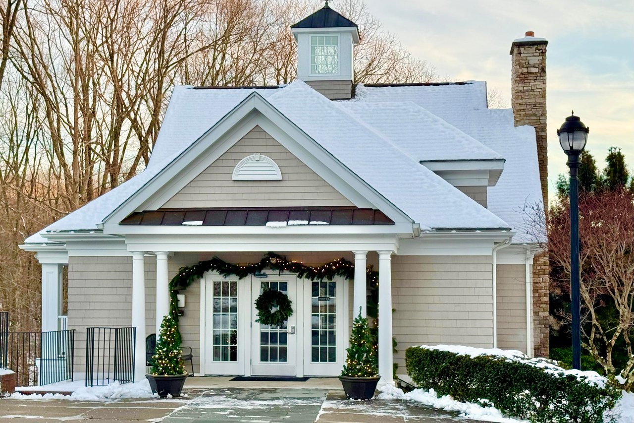 Clubhouse with fitness center, locker rooms, and gathering room with fireplace, bar & kitchen.