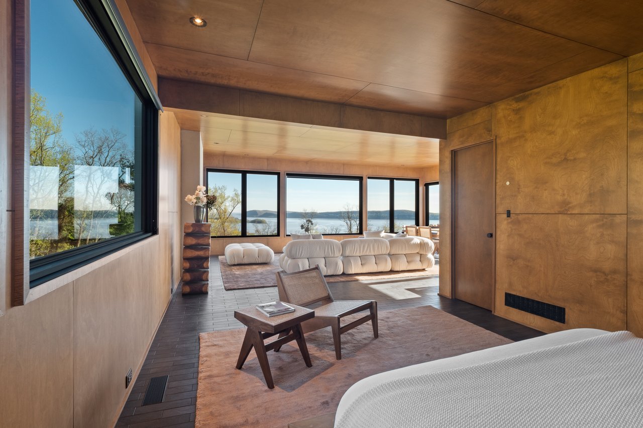 Bedroom with a water view, wooden ceiling, and dark wood-style flooring