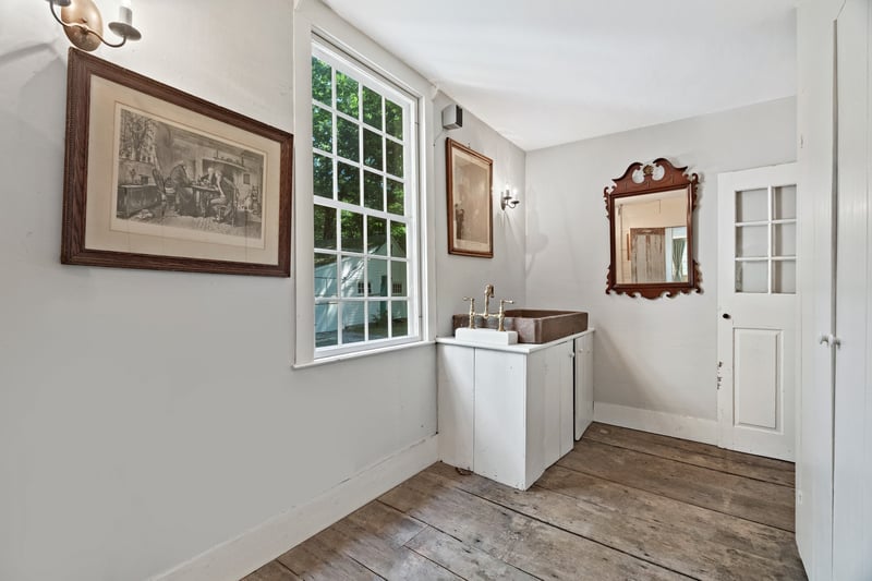 The dinner service room has a handsome and unique large stone sink juxtaposed with modern water fixtures.