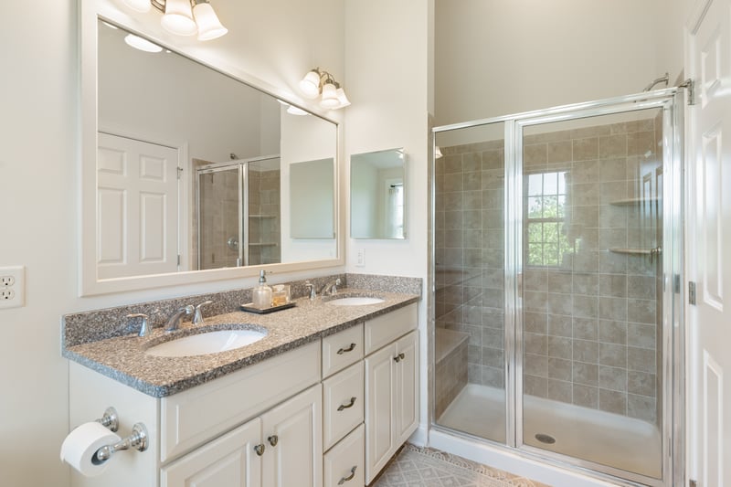 The primary bathroom ensuite has a dual vanity and seated large shower.	