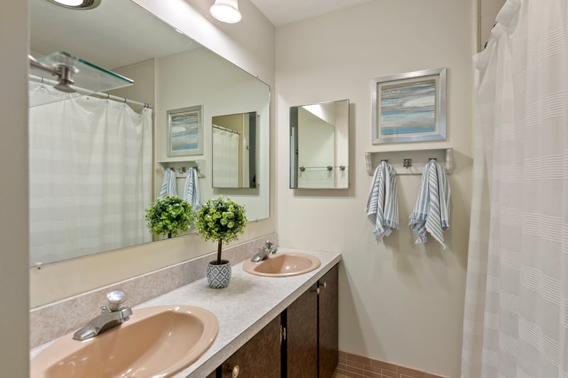Upstairs hall bathroom has double sinks and tile floor