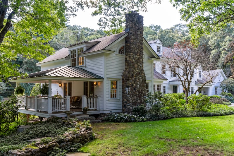 Primary bedroom suite graces east side of the home with fieldstone chimney and gorgeous open porch