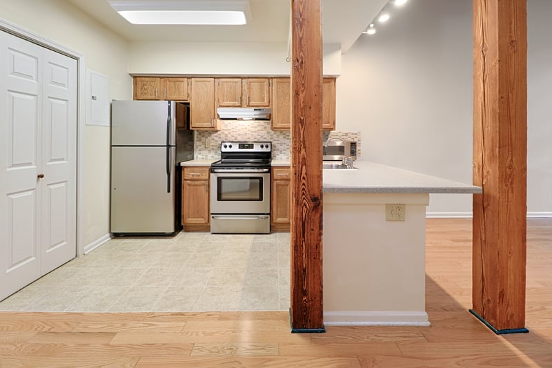 There are full sized stainless appliances in the kitchen, with a new tile floor. Note the overhang on the counter for stools to slide under for casual dining.