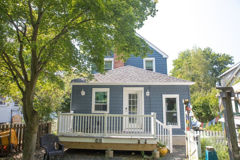 Rear view of house with fence and roof with shingles