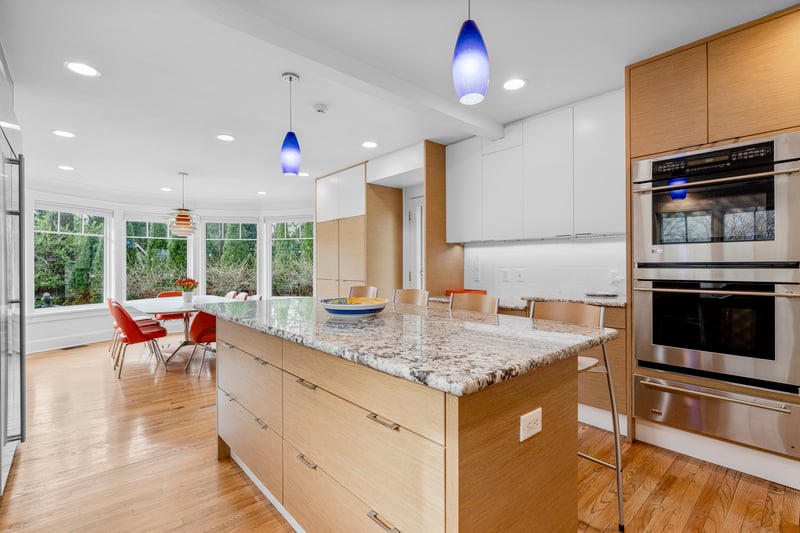 Kitchen with modern cabinets, a center island, a warming drawer, and double oven