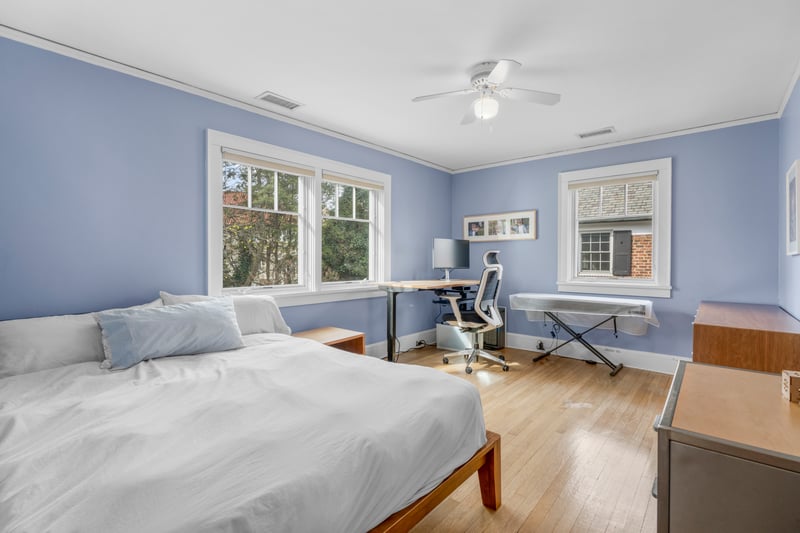 Bedroom with light wood-type flooring, visible vents, crown molding, and ceiling fan
