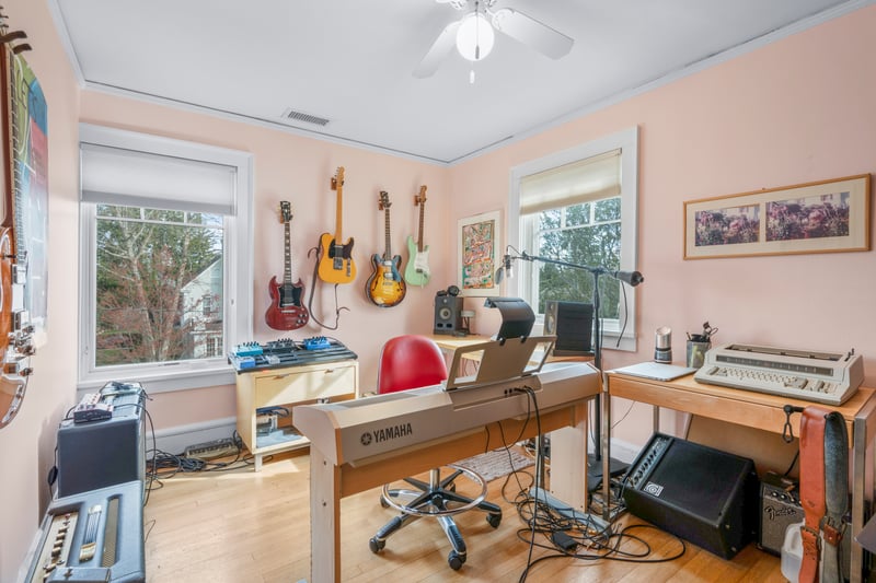 Office area with wood finished floors, visible vents, a ceiling fan, and a wealth of natural light