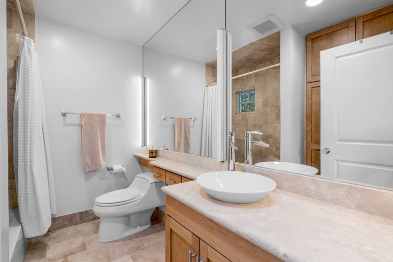 Bathroom with toilet, a shower with curtain, vanity, and visible vents