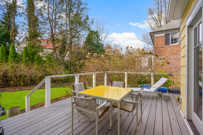 Wooden terrace featuring a lawn and outdoor dining space