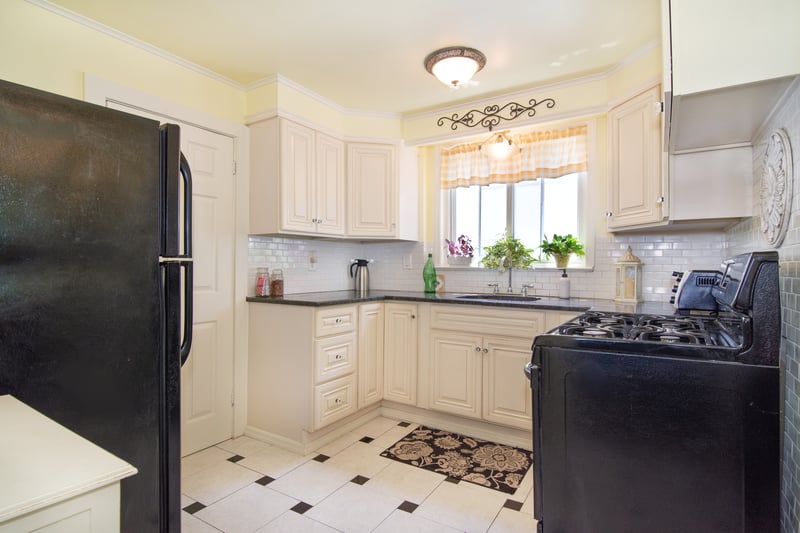 A thoughtfully updated kitchen features black granite countertops and coordinated appliances for a sleek, modern look....