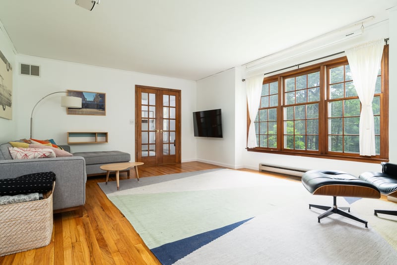 Living area with wood finished floors, french doors, baseboards, and a baseboard radiator...