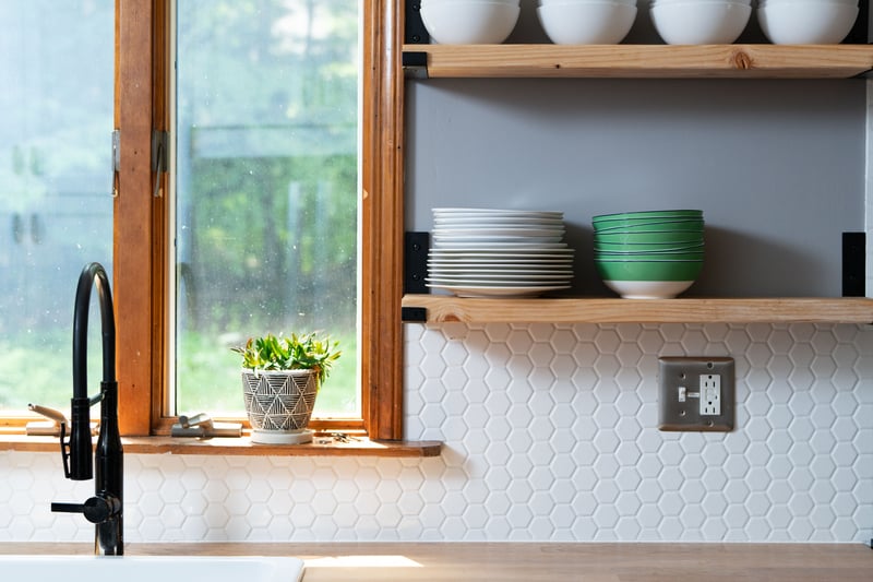 Kitchen view of a sink, open shelves, white cabinetry, and butcher block countertops