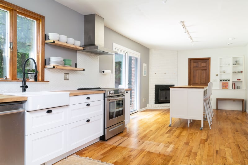 Kitchen featuring butcher block counters, appliances with stainless steel finishes, wall chimney exhaust hood, a sink, and plenty of natural light