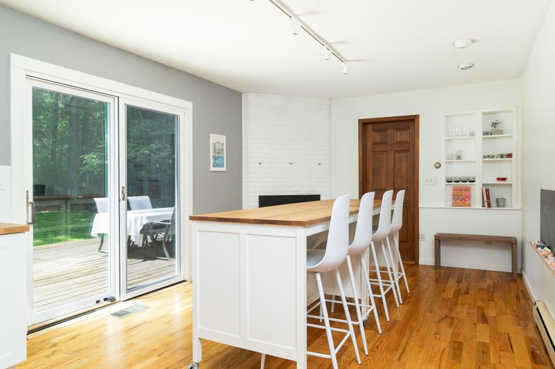 Kitchen with wooden counters, rail lighting, a baseboard heating unit, white cabinets, and light wood-type flooring