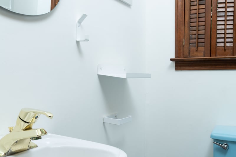 Half bath featuring baseboards, toilet, and a sink