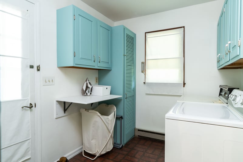 Washroom with cabinet space, a baseboard heating unit, washer and dryer, and brick patterned floors