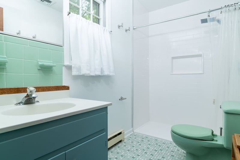 Full bathroom featuring a baseboard radiator, vanity, and a tile shower