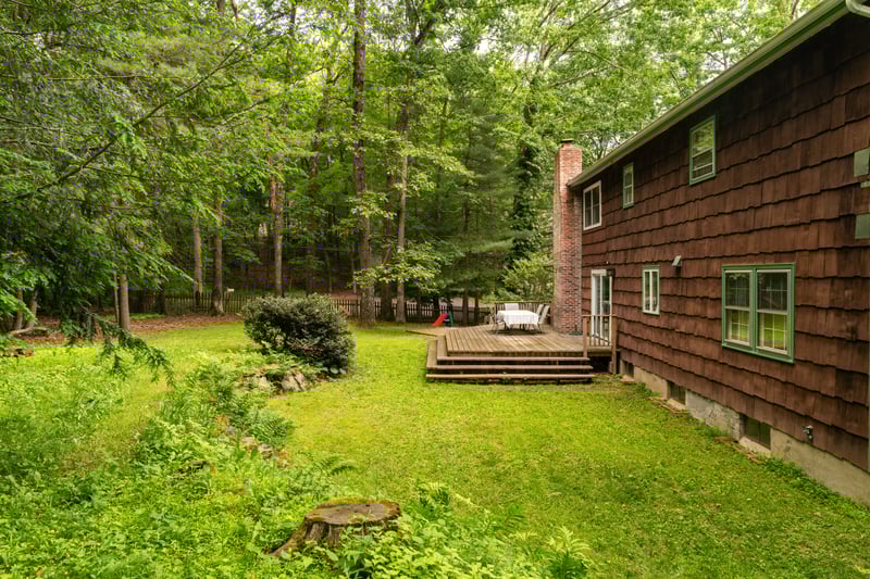 View of grassy yard with a deck