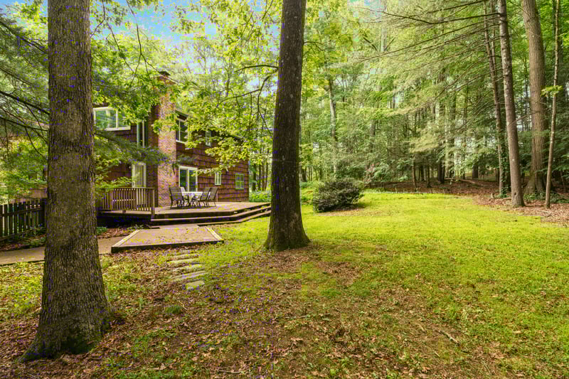 View of grassy yard featuring a wooden deck