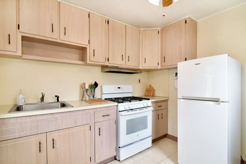 Neutral cabinetry and white appliances lend a touch of brightness to the kitchen.