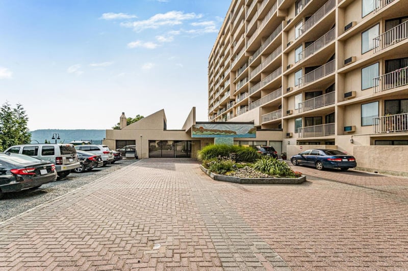 View of building exterior featuring uncovered parking
