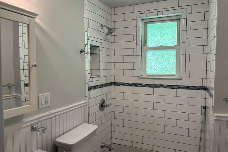 Bathroom featuring tub / shower combination and a wainscoted wall