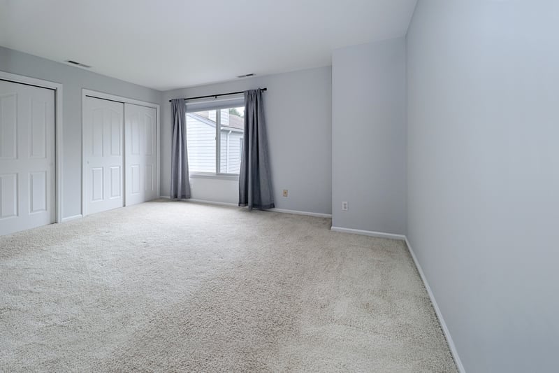 Primary suite features wall to wall carpet and double closets.