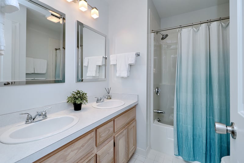 Primary bathroom features a vanity with double sinks, new faucets, tile floor and a tub/shower combination.