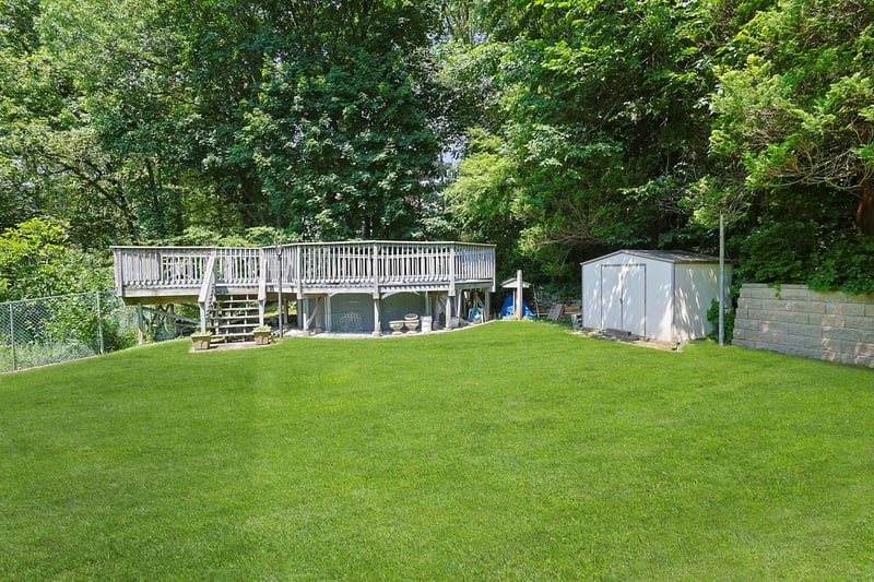 View of yard featuring a deck and a storage shed