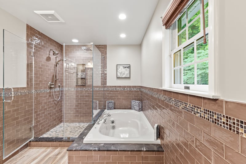 Recently Updated Bathroom with a stall shower, a whirlpool tub, plenty of natural light, tile walls, and recessed lighting
