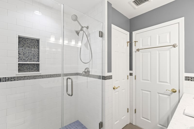 Recently Updated Hall bathroom with shower, plenty of natural light, double vanity, and wainscoting