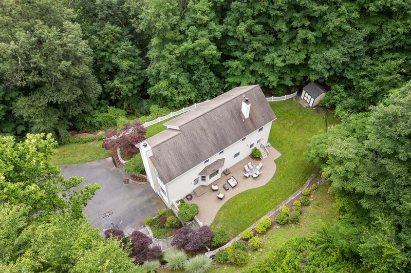 View from above of home featuring a beautiful walkway, stonewalls , mature plantings and greenery