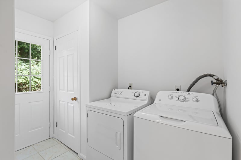 Laundry room with washing machine and dryer plus access to the back of the home.