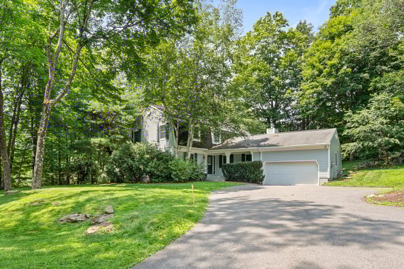 View of front facade featuring asphalt driveway, a 2 car garage, front lawn