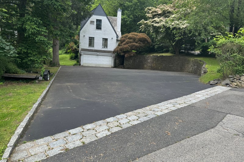 View of front of home featuring a chimney, asphalt driveway, and a garage