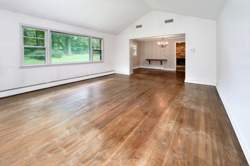 Another view of living room with picture window providing great views of verdant backyard.