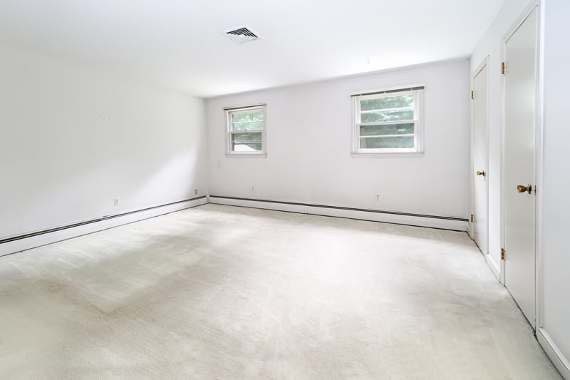 Primary bedroom with hardwood floor, wall-to-wall carpet and full bath.