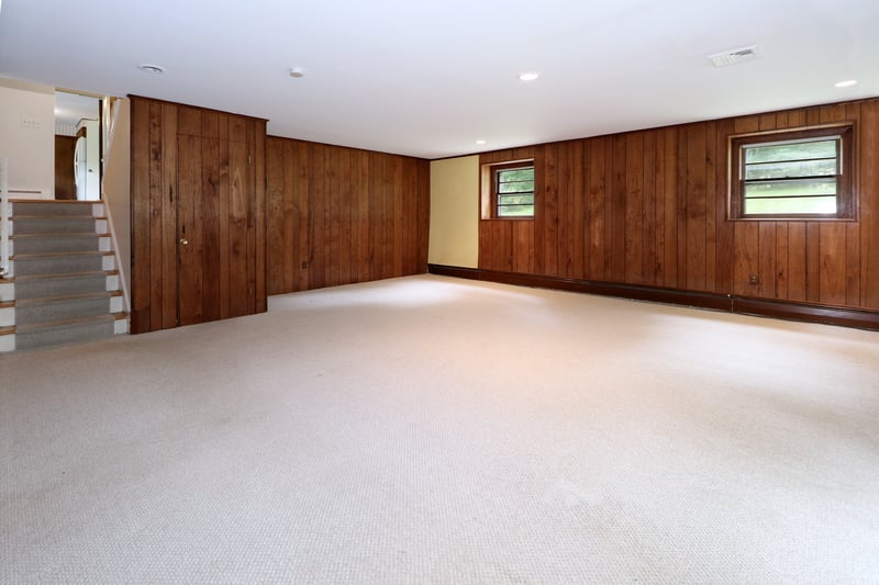 Alternate view of lower level recreation room with stairs to basement and main levels.